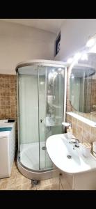 ein Badezimmer mit Dusche und weißem Waschbecken in der Unterkunft Ada Old Town Apartments 3 in Braşov