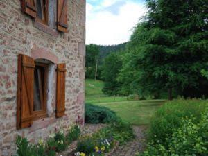un edificio in mattoni con una finestra sul lato di Superbe Ferme Rénovée avec Cheminée, Wifi, et Jeux Extérieurs près de Gérardmer et Épinal - FR-1-589-28 a Belmont-sur-Buttant