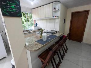 a kitchen with a counter with chairs and a counter top at Casa da Floresta in Paraty