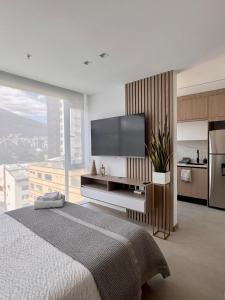 a bedroom with a flat screen tv and a bed at New Mini Suite, La Carolina in Quito