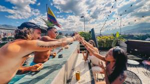 a group of people holding hands on a rooftop at Los Patios Hostel Medellin in Medellín
