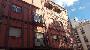 un edificio rojo con balcones en un lateral en Apartamento Anaper, en Málaga