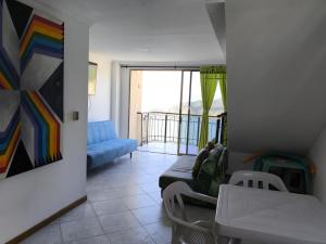 a living room with a couch and a balcony at Edificio El Peñon del Rodadero Apartamento Playa in Santa Marta
