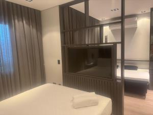 a bedroom with a large tv and a bed with a bed sqor at Suites in B Tree Av Paulista in Sao Paulo +6 photos