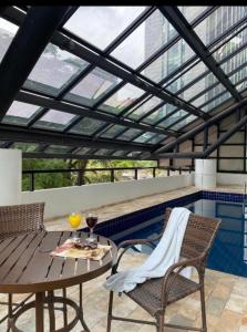 a patio with a table and chairs and a swimming pool at Suites in B Tree Av Paulista in Sao Paulo