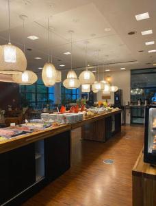 a buffet line in a restaurant with pendant lights at Suites in B Tree Av Paulista in Sao Paulo