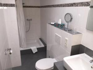 ein Badezimmer mit einem WC, einem Waschbecken und einem Spiegel in der Unterkunft Pension im Wirtshaus Himberg in Bad Honnef am Rhein