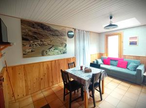 a living room with a table and a couch at Gîte Ha-Py Chalet in Campan