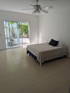 une chambre avec un lit et un ventilateur de plafond dans l'établissement Peregrina 2 bdr In Heart of Playa, à Playa del Carmen