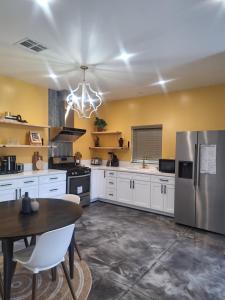 eine Küche mit weißen Schränken und einem Edelstahlkühlschrank in der Unterkunft Azusa in Azusa
