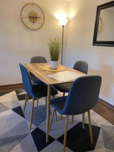 a dining room table with blue chairs and a lamp at Linda Instalación con estacionamiento in Los Ángeles