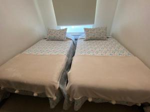 two twin beds in a small room with a window at Linda Instalación con estacionamiento in Los Ángeles +2 photos