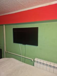 ペトロヴァラディンにあるApartman Petrovaradinのベッドの上に壁掛け式の薄型テレビが備わります。