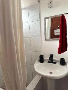 a white bathroom with a sink and a mirror at La Caille Créole in Roseau +39 photos