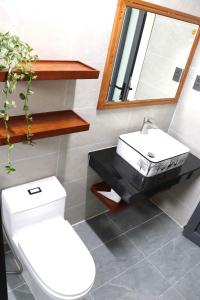 a bathroom with a white toilet and a sink at Chiri House in Khu Chi Lăng