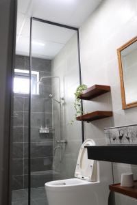 a bathroom with a toilet and a glass shower at Chiri House in Khu Chi Lăng