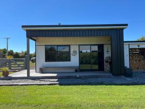 a small house with a large window in a yard at Tau Studio - Boutique Accommodation in Ohakune +7 photos
