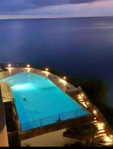 a large swimming pool with lights in front of the ocean at Edificio El Peñon del Rodadero Apartamento Playa in Santa Marta +15 photos