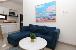 a living room with a blue couch and a table at Rivera Villa Seminyak in Seminyak