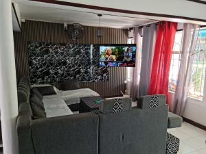 a living room with a couch and a flat screen tv at Bungalow 3 BedRooms, Garden, beach in Flic-en-Flac