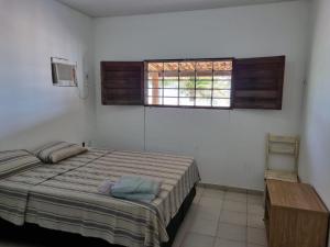 a bedroom with a bed and a window at Lucena praia in Lucena