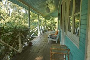 eine Veranda mit einer Bank und einem Stuhl auf einem Haus in der Unterkunft Isla El pantano delta, Tigre in San Fernando