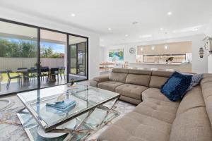 ein Wohnzimmer mit einer Couch und einem Glastisch in der Unterkunft Pengana Beach Retreat Mornington Peninsula in Rosebud