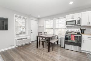 a kitchen with white cabinets and a table with chairs at Downtown Kimmswick Studio-Renovated-Prime Location in Imperial