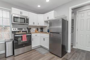 a kitchen with white cabinets and a stainless steel refrigerator at Downtown Kimmswick Studio-Renovated-Prime Location in Imperial