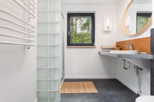 a bathroom with a sink and a mirror at Holiday Home by Lake Wise ka with Sauna in Wisełka +22 photos