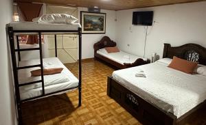a room with two bunk beds and a tv at Finca Hotel La Paloma in Quimbaya +4 photos