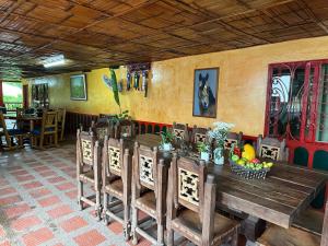 a dining room with a wooden table and chairs at Finca Hotel La Paloma in Quimbaya