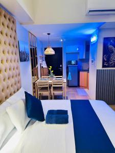 a bedroom with a large bed and a kitchen at We Vibe, 81 Newport Blvd across NAIA 3 in Manila