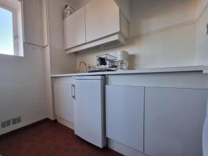 une cuisine avec des armoires blanches et un évier dans l'établissement Studio avec terrasse, parking à 170m de la plage - FR-1-309-463, à Collioure 4 autres photos