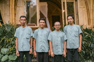 a group of men standing in front of a building at Arcada Bali Bamboo House in Sidemen