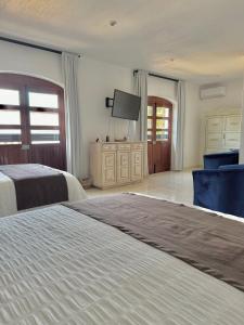 a bedroom with two beds and a flat screen tv at Suite Los Angeles in Tecozautla
