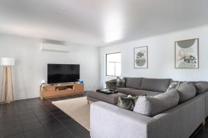 a living room with a couch and a flat screen tv at Stylish Family Retreat by Hawley Beach in Hawley Beach