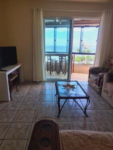 un salon avec un canapé et une table dans l'établissement Apartamento Pé na Areia, a 12 min do Beto Carrero, à Navegantes 37 autres photos