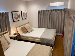 een slaapkamer met twee bedden en een raam bij Shin-Nakano House in Tokyo