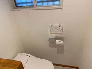 een kleine badkamer met een toilet en een raam bij Shin-Nakano House in Tokyo