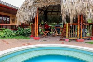 a swimming pool in front of a house with a patio at Finca Hotel La Paloma in Quimbaya