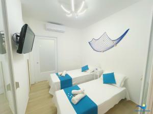 a small room with two beds and a tv at VILLA PERLA del SALENTO con piscina in Lido Marini