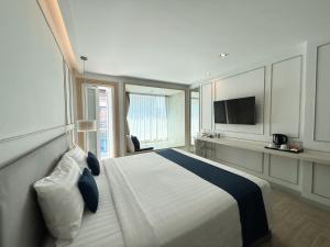 ein Hotelzimmer mit einem Bett und einem Fernseher in der Unterkunft The Bloc Hotel Phuket - SHA Extra Plus in Patong Beach