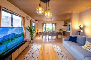 a living room with a large tv and a table at Villa MILA MOTOBU in Motobu