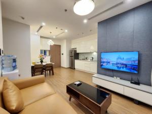 sala de estar con sofá y TV de pantalla plana grande en Skylake Phạm Hùng, en Hanói