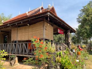 a house with a porch and flowers in front of it at Chanmolfarmstay in Phumĭ Chŭb Chănt Sâr