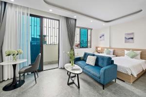 a hotel room with a bed and a blue couch at Hanoi Cosmos Hotel in Hanoi +52 photos