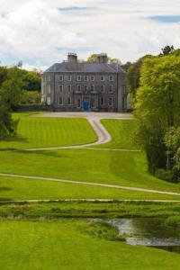 a large building on a grassy field with a road at Ballyhoura Country Retreat 1 Bedroom Apartment in Kildorrery