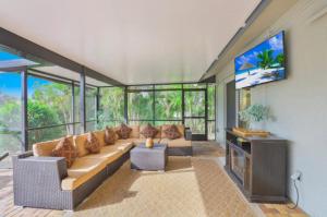 a living room with a couch and a flat screen tv at 1209 Marco Island in Marco Island