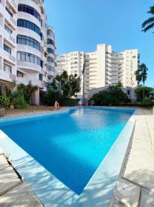 a large blue swimming pool in front of some buildings at Porlamar La Reserve frente a La Vela in Porlamar